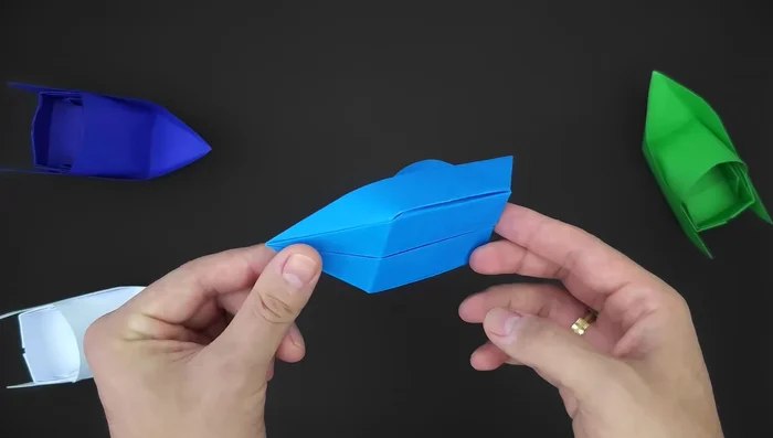 Fold creating two diagonals. Bring the right side to the middle, make a crease; repeat on the left side. Fold the paper along these two small diagonal lines.