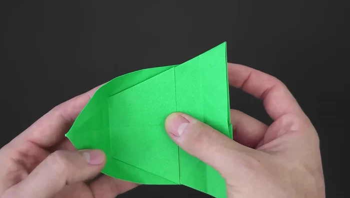 Unfold. Separate the inner layer, bring one part behind the other, align, and reinforce. Repeat on the other side.