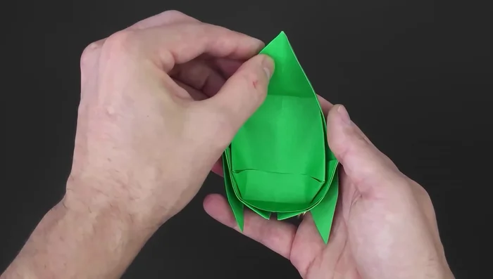 Unfold the paper, place it between the inner layers to hide the part and make it neater. Repeat on the other side.