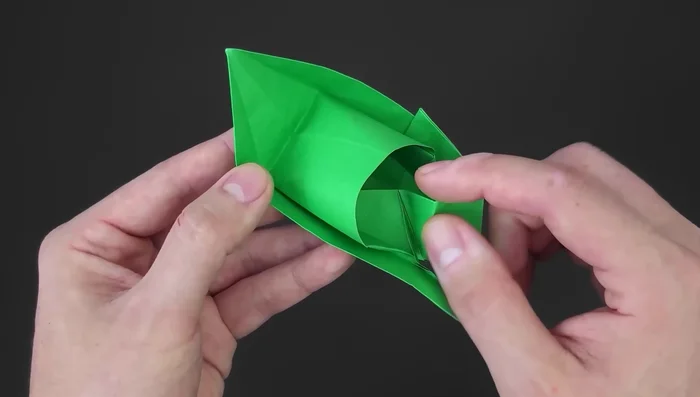Unfold the paper, place it between the inner layers to hide the part and make it neater. Repeat on the other side.