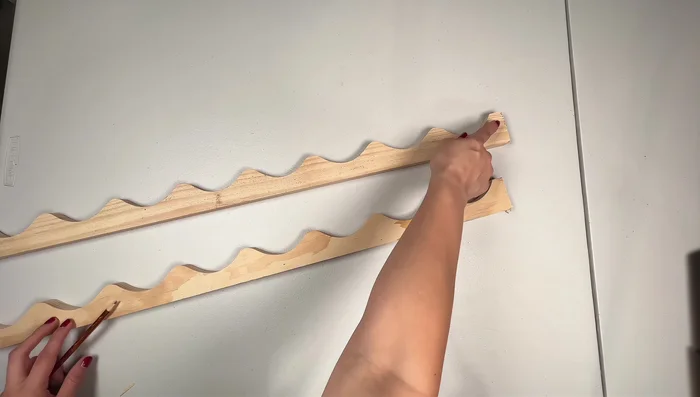 Prepare and attach decorative trim from wine rack. Cut and glue pieces together to create scalloped design.