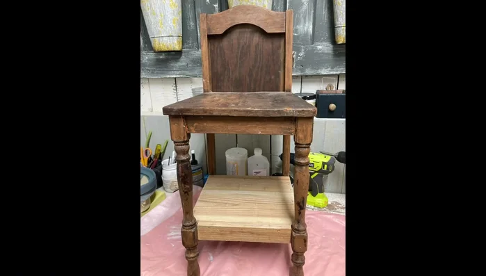 Create shelves: Cut and attach boards to the bottom of the chair to form a lower shelf. Add a smaller board to the front for a finished look. A piece of luan is added to the back of the top opening to create a second shelf.