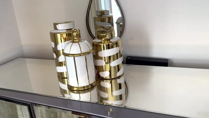 Decorate end tables with functional and decorative items such as books, bags, and candle holders.