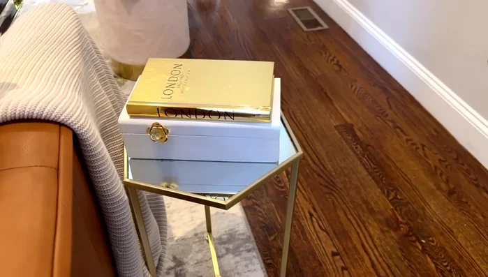 Decorate end tables with functional and decorative items such as books, bags, and candle holders.