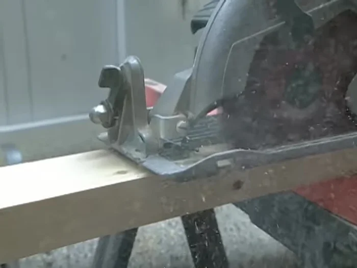 Cut and install the first rail: Cut the rail along the scribed line. Position the rail on the floor and check for level. Attach it securely using construction adhesive and screws.