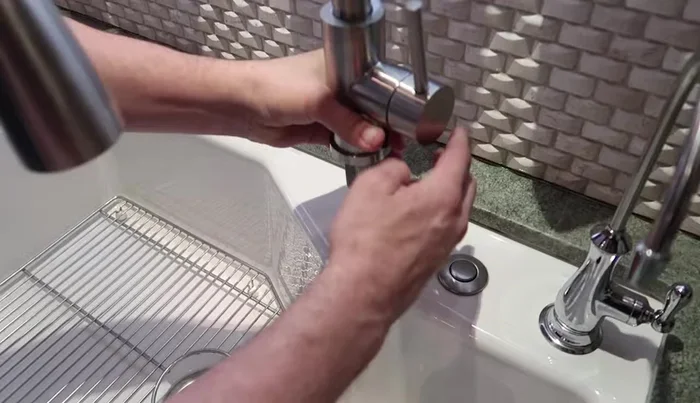 Secure the faucet with the nut, washer, and gasket. Tighten the screws on the nut evenly.