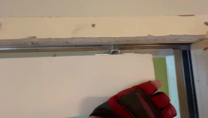 Install the new door into the pocket, starting with the wheel closest to the pocket.