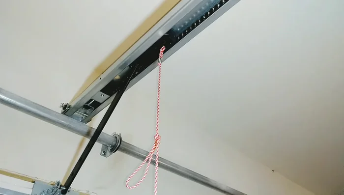 Secure the garage door using dowel rods and clamps to prevent it from dropping.