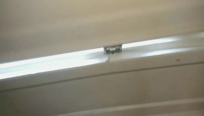 Secure the garage door using dowel rods and clamps to prevent it from dropping.