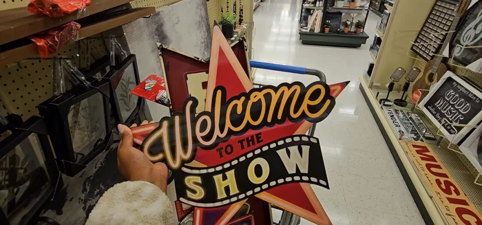 Purchase necessary items: In this case, they chose a ‘Welcome to the Show’ star sign, snack bar signs ('Snack Bar Treat Yourself', 'It's Snack Time'), a movie ticket, Coca-Cola items, and an exit sign.