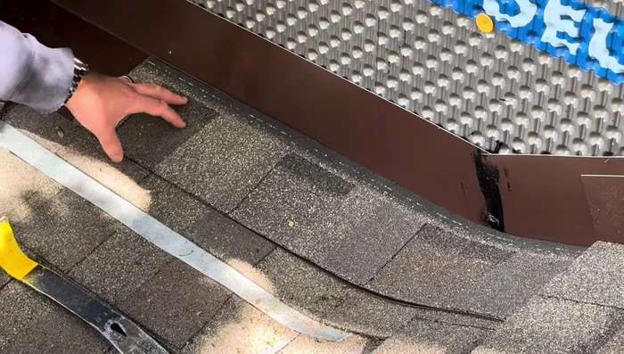 Apply the final layer of shingles over the flashing, securing only with roofing caulk (not nails).