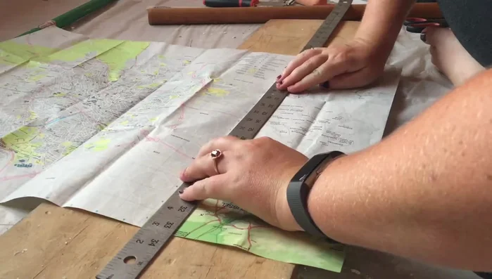 Trim excess map edges using a straightedge and razor blade for clean lines.