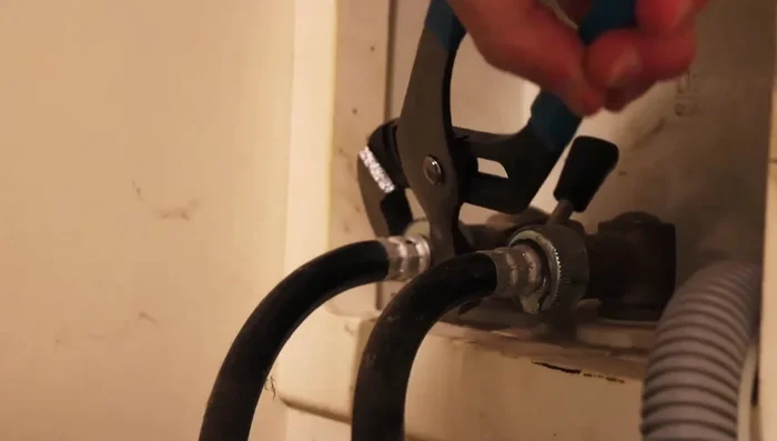 Remove the old hoses from the back of the washing machine. Be prepared for some water leakage.