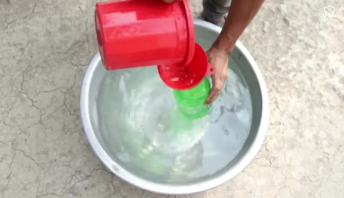 Finishing touches: Fill the larger bottle with water and attach the cap assembly