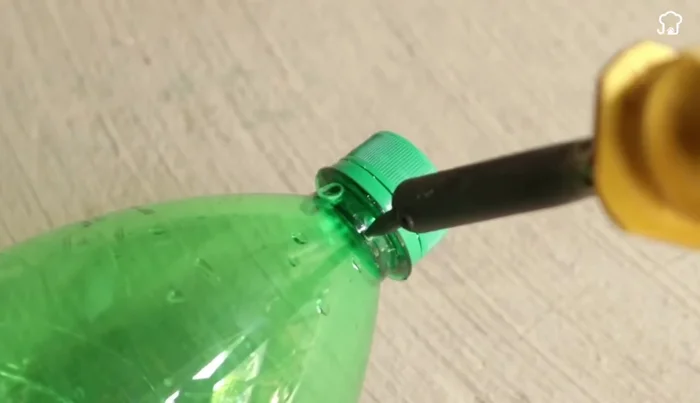 Attach the metal hook: Thread the metal hook through the bottom of the larger bottle