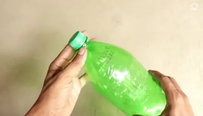 Attach the metal hook: Thread the metal hook through the bottom of the larger bottle