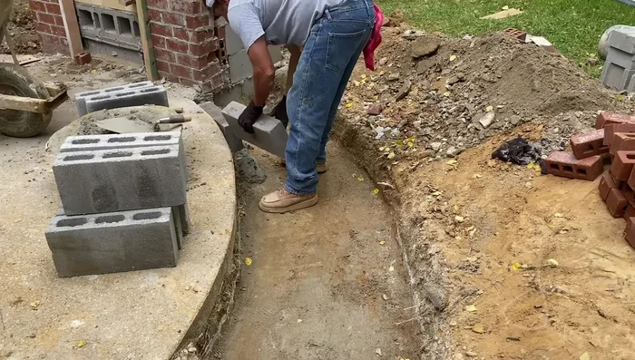 Build the bench seating: Utilize lightweight concrete blocks to construct the seating area, three blocks high for the seat and adding a backrest.