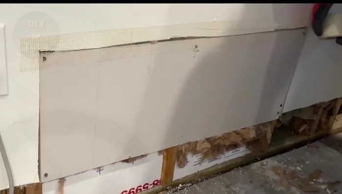 Apply the first coat of drywall compound, focusing on filling gaps and cavities.