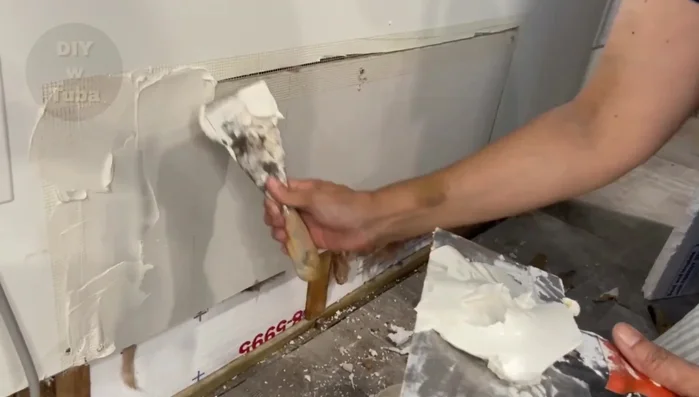 Apply the first coat of drywall compound, focusing on filling gaps and cavities.