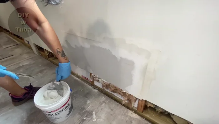 Apply a second coat of drywall compound (dust control type recommended), spreading it evenly along the tape line.