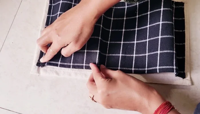 Sew the bottom of the pockets. Divide the remaining fabric at the bottom equally and sew from the bottom toward each pocket.