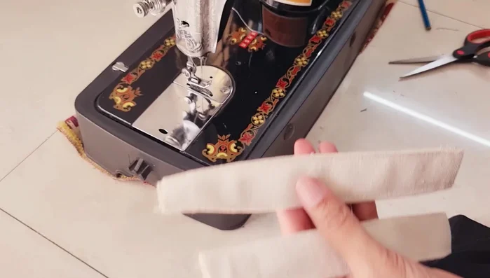 Create the hanging strip. Cut strips from the base fabric and sew them to the top of the organizer for hanging.