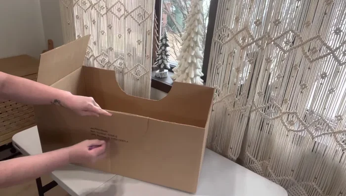 Assemble the car body: Hot glue the red poster board onto the front and back of the cardboard structure, then attach the side pieces. Trim excess poster board.