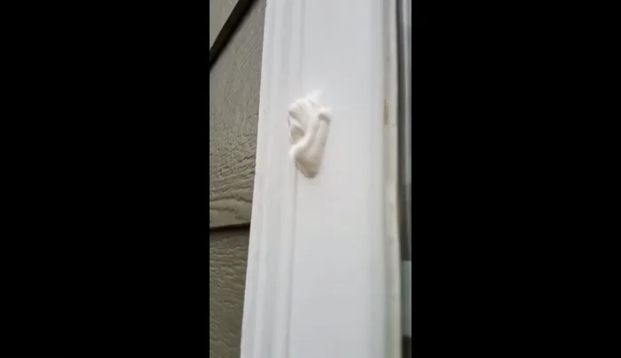 Trim excess caulk with a razor blade, making it flush with the window surface.