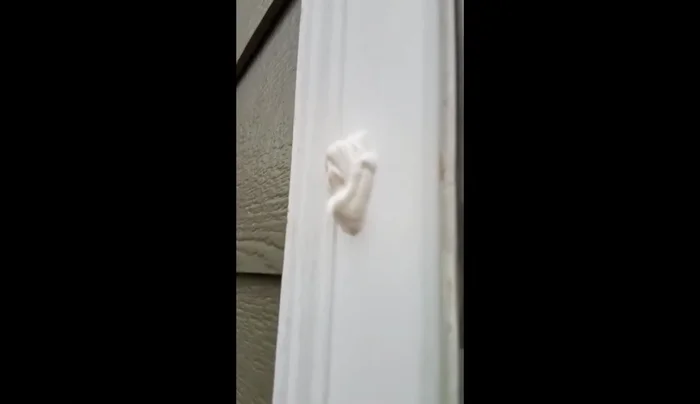 Trim excess caulk with a razor blade, making it flush with the window surface.