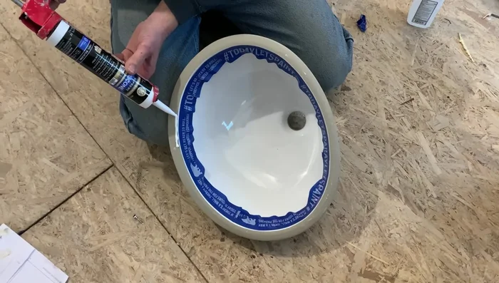 Apply silicone, set the sink in place, and secure it using sink hardware.