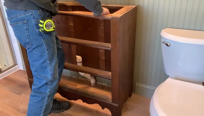 Set the dresser top in place and attach it with screws. Install new drawer hardware.