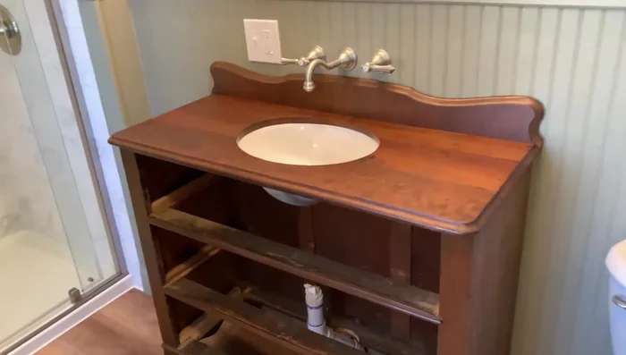Set the dresser top in place and attach it with screws. Install new drawer hardware.