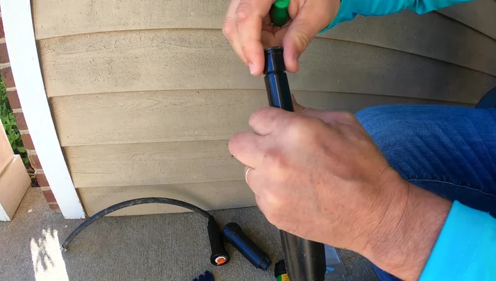 Use the appropriate tool (or a flathead screwdriver) to adjust the nozzle. If it's a new sprinkler head, remove the cap and install the nozzle.