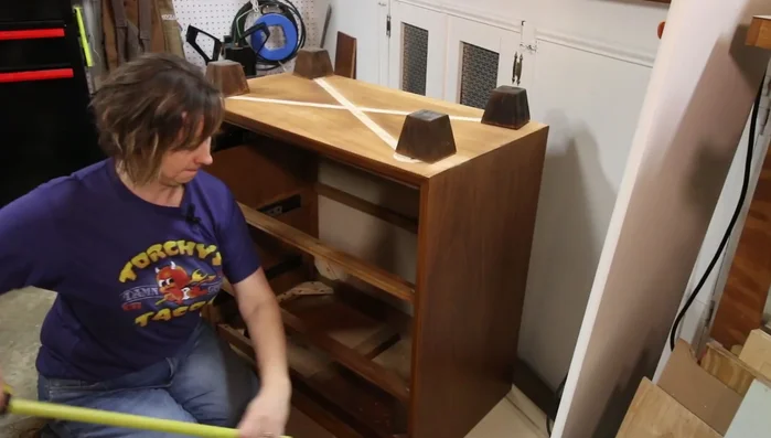 Remove the dresser legs and replace them with square feet, securing them with wood glue and trim nails.