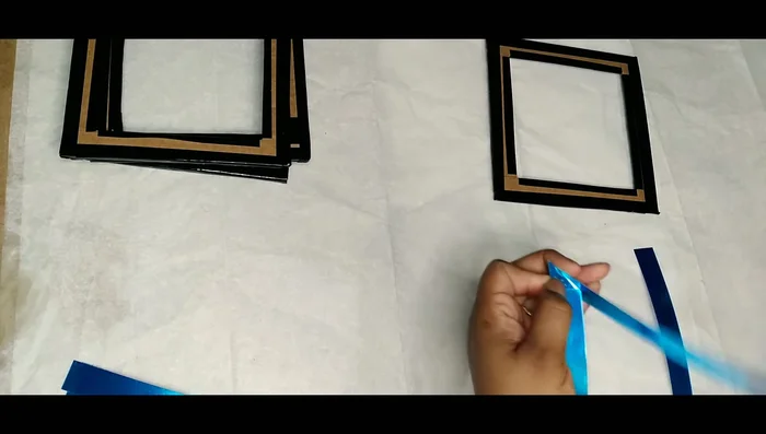 Adhere the mirror strips to the cardboard squares, ensuring a neat fit.