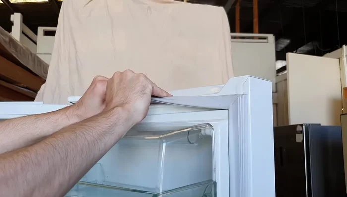 Once the adhesive is loosened, carefully remove the old seal.