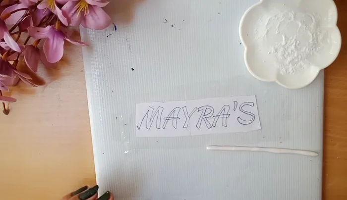 Stick the name onto the board with glue.