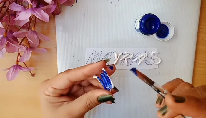 Stick the name onto the board with glue.