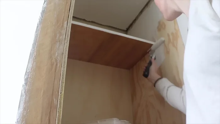 Sand the face frame and doors to create a smooth surface for painting or finishing.