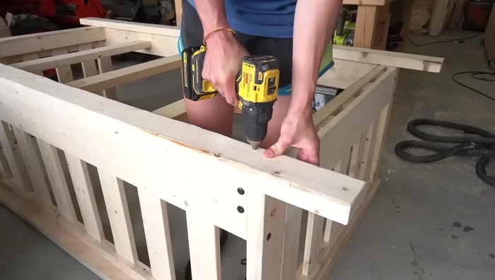 Drill holes through the bottom 2x4s to attach the ropes. Use a 3/4 inch Forstner bit for clean holes.