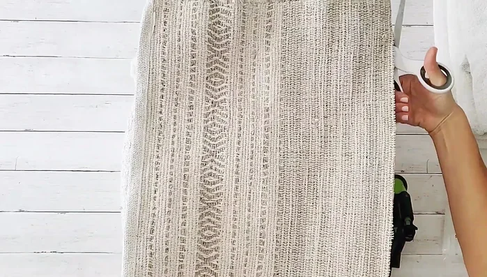 Cut the third rug in half. Glue one half to the bottom (inside-out) side of the pouf, right sides together.