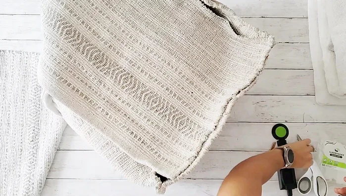 Flip the pouf inside out to conceal the raw edges. Glue the other half of the third rug to the remaining open side.