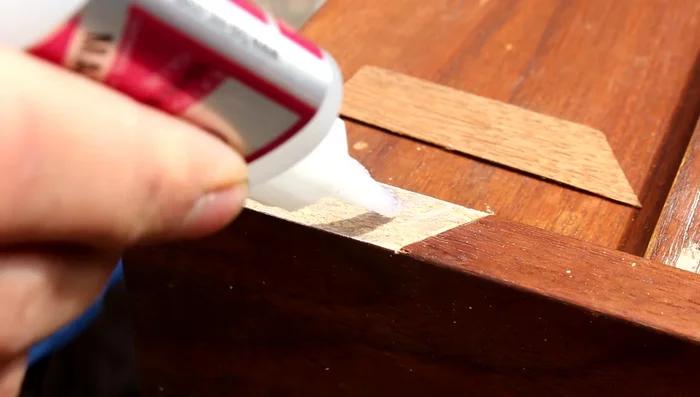 Press the veneer patch firmly into place and let it dry completely.