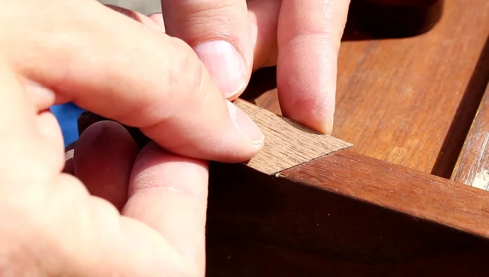 Press the veneer patch firmly into place and let it dry completely.