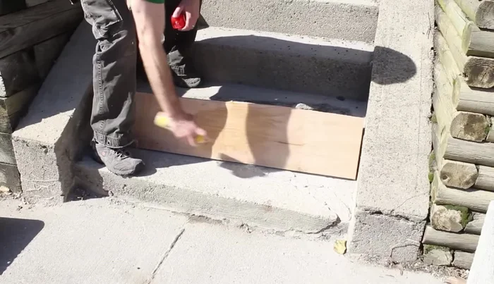 Place the form flush against the old step, securing it with cinder blocks to ensure it’s plumb.