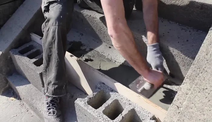 Use a steel trowel to smooth the edges between the new and old cement, checking for levelness with a 24-inch level. Fill low spots and scrape off high spots.