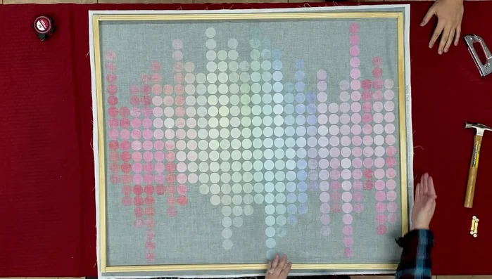 Staple the top and bottom edges of the fabric to the frame, stretching the fabric evenly. Tuck the corners to create a neat finish and staple them securely.