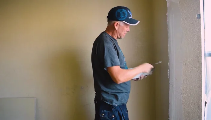 Apply a first coat of mud, ensuring full coverage of the tape. Check for any protruding nails or other imperfections and address them.