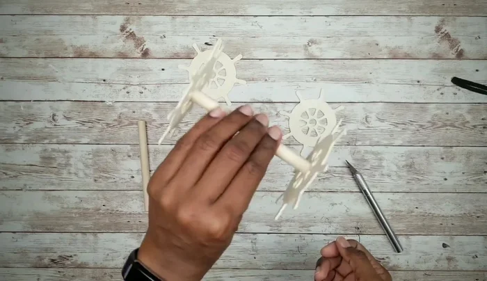 Attach the dowel rod wheels to the cutouts and smooth the edges.