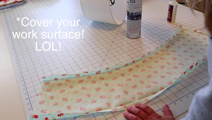 Spray the back of your fabric template with adhesive. Carefully roll the lampshade onto the fabric, smoothing out any creases.